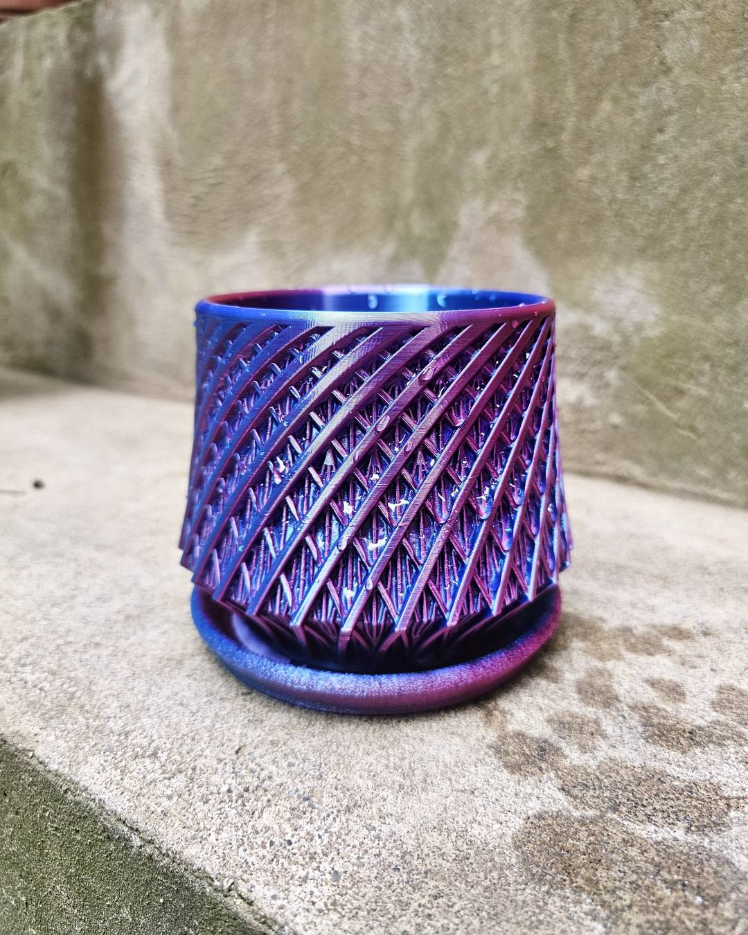 A color-shifting vase with a spiraled, textured surface that shifts between blue and purple in the light.