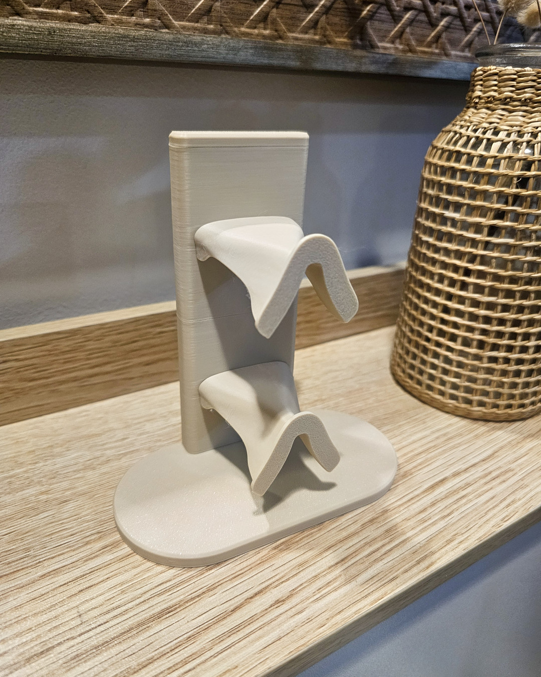 A pair of S-shaped 3D printed wall hooks in a neutral color.